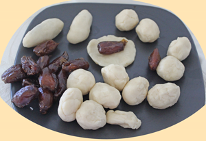 Ball of dough, dates and dates being enclosed in dough